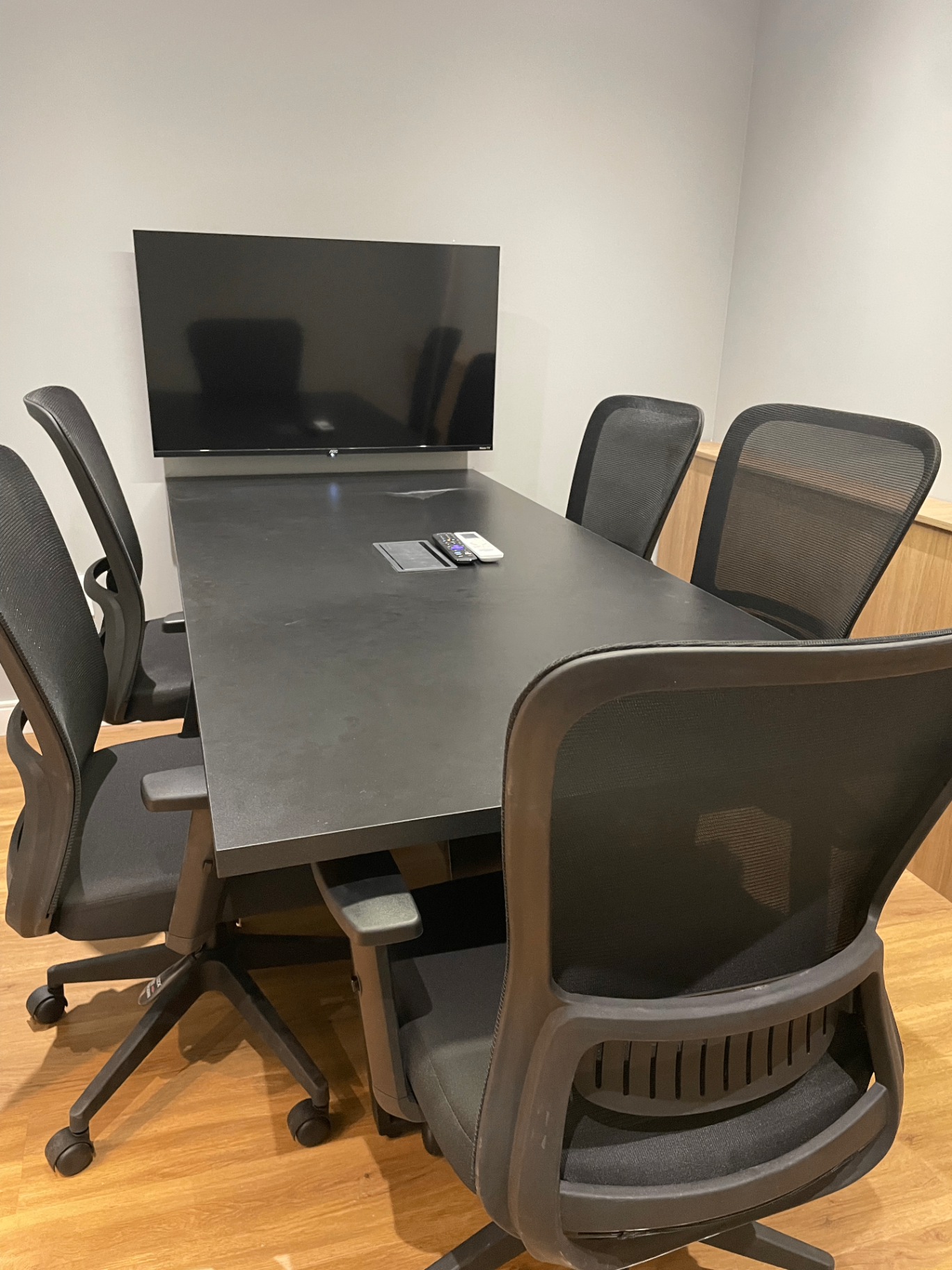 Sala de reuniões profissional equipada com TV, mesa ampla e climatização em Vitória/ES